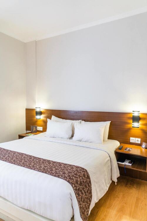 Chambre lit double grande tête de lit avec tables de chevet, lampes et prises de courant intégré